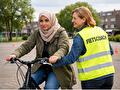 een vrouw op een fiets met een vrouwelijke fietscoach ernaast
